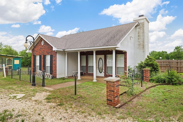 view of front of home featuring fence, a shingled roof, a chimney, and brick siding