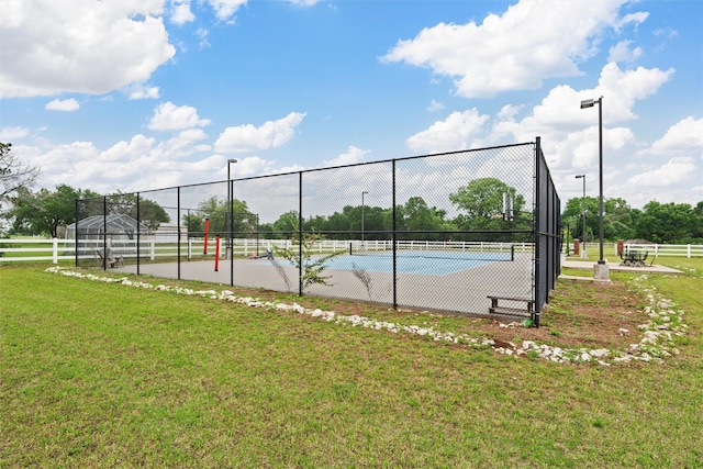 view of sport court featuring a lawn and fence