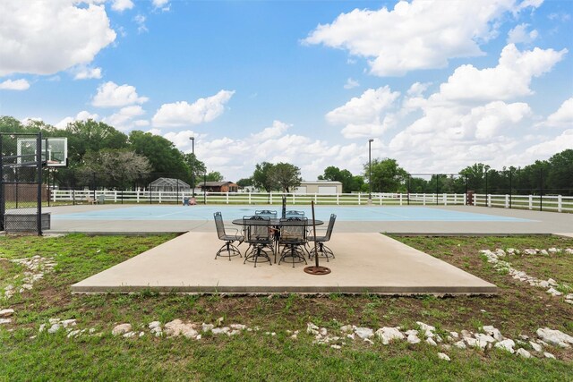 view of patio featuring community basketball court and fence