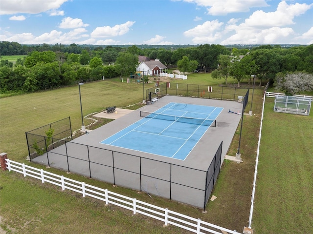 view of basketball court with fence, a tennis court, and a yard