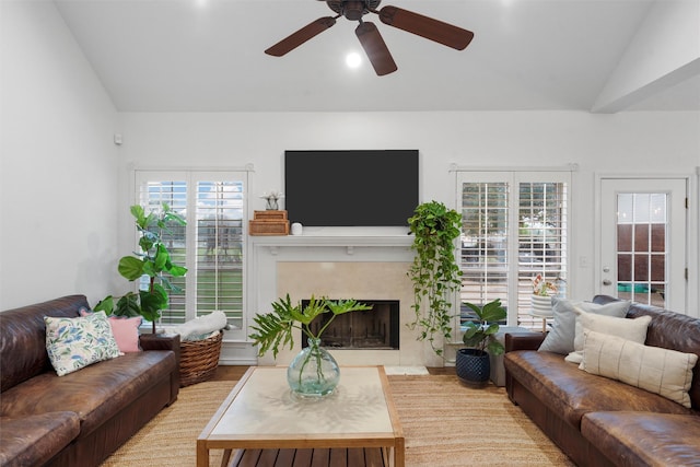 living room featuring a premium fireplace, ceiling fan, vaulted ceiling, and wood finished floors
