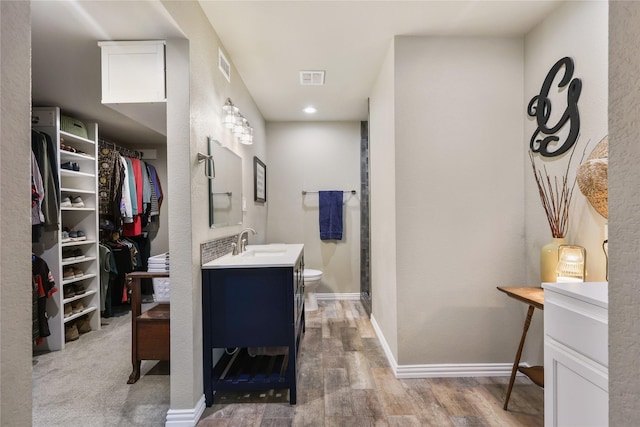 full bathroom with vanity, toilet, wood finished floors, and visible vents