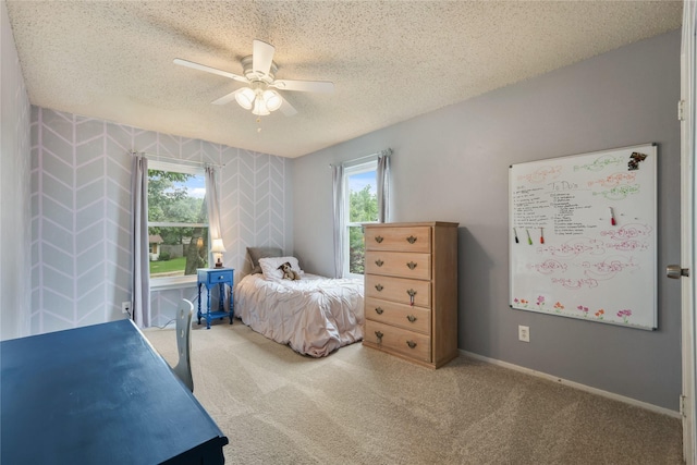 carpeted bedroom with baseboards, ceiling fan, and a textured ceiling