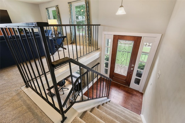 entryway with baseboards, a healthy amount of sunlight, stairway, and wood finished floors
