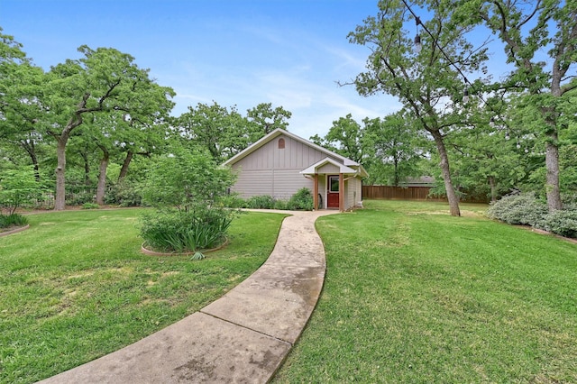 view of front of property with fence, board and batten siding, and a front lawn