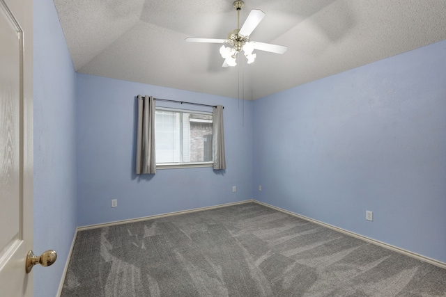 carpeted spare room featuring baseboards, ceiling fan, and a textured ceiling
