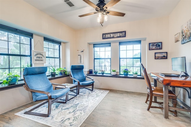 office area with a ceiling fan, wood finished floors, and visible vents