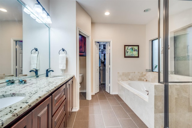 full bath with tile patterned flooring, toilet, a bath, a shower stall, and a sink