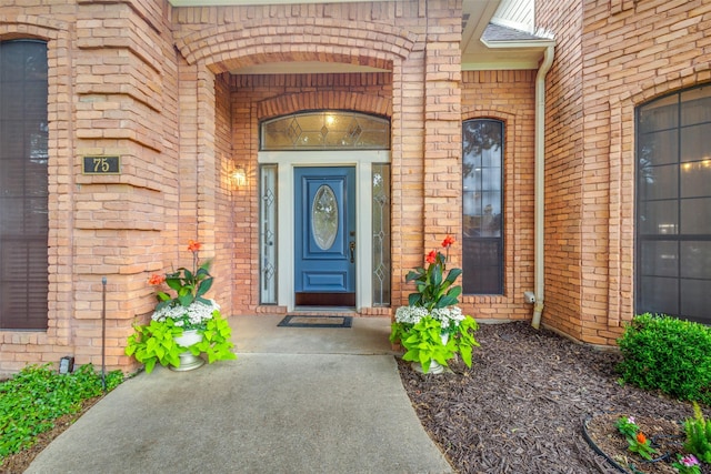 view of exterior entry with brick siding