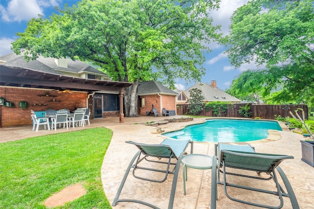 view of swimming pool featuring a yard, a ceiling fan, a fenced backyard, and a patio area