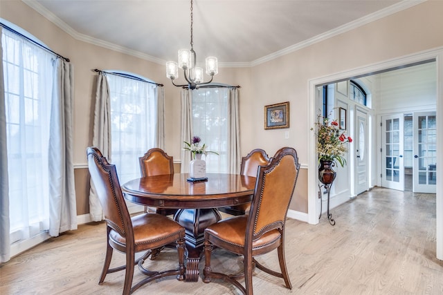 dining room featuring crown molding, light wood finished floors, a chandelier, french doors, and baseboards
