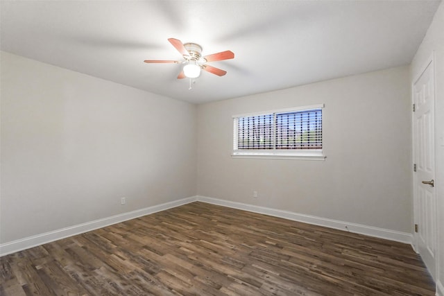 empty room with baseboards, a ceiling fan, and dark wood finished floors