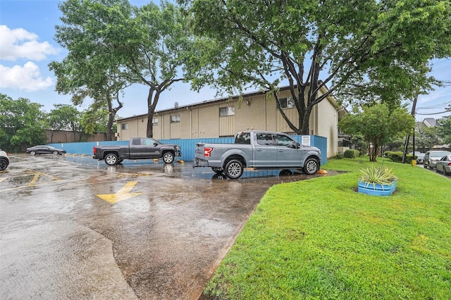 exterior space with uncovered parking and a front yard