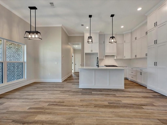 kitchen with crown molding, white cabinets, light wood-style floors, light countertops, and baseboards