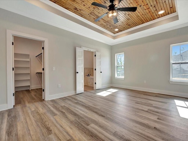 unfurnished bedroom with baseboards, ornamental molding, a raised ceiling, and wood ceiling