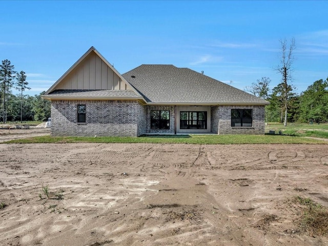 back of house with brick siding and board and batten siding