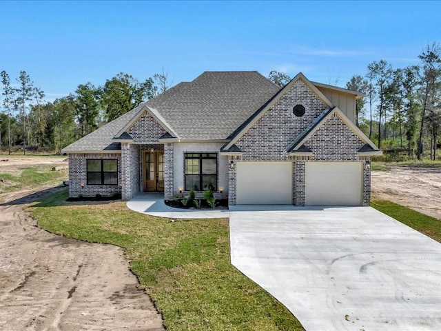 view of front facade featuring driveway, a garage, brick siding, a front lawn, and a shingled roof