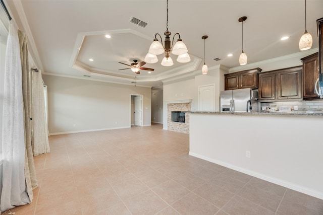kitchen featuring backsplash, visible vents, light stone countertops, dark brown cabinets, and stainless steel fridge with ice dispenser