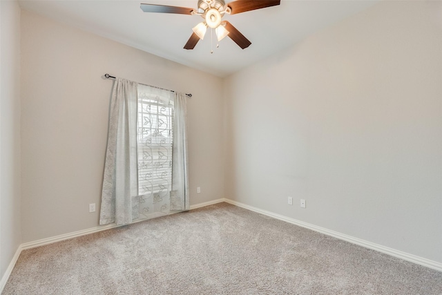 spare room featuring carpet floors, baseboards, and ceiling fan