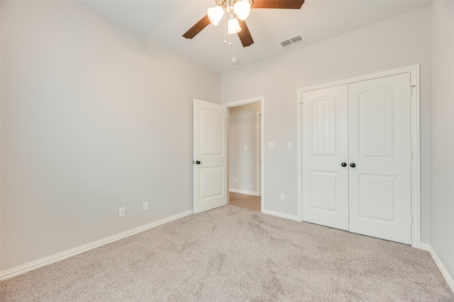 unfurnished bedroom featuring a ceiling fan, visible vents, baseboards, a closet, and carpet