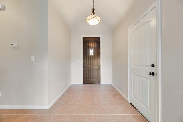 entrance foyer featuring baseboards, light tile patterned floors, and lofted ceiling