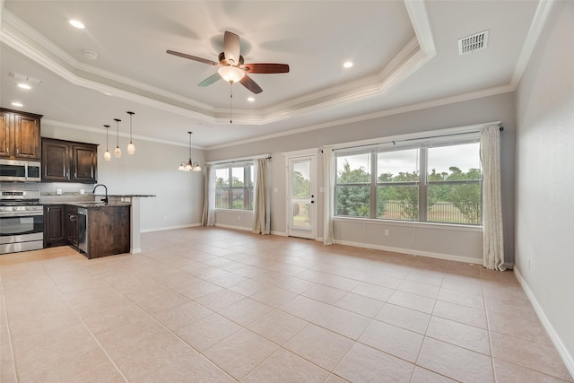 kitchen with appliances with stainless steel finishes, a sink, ceiling fan with notable chandelier, a tray ceiling, and visible vents