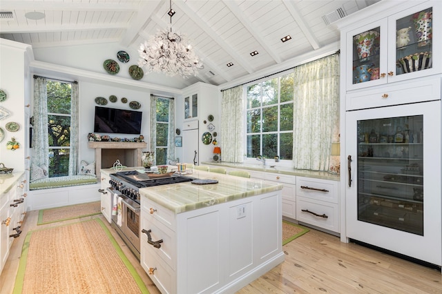 13230 Miller Rd, Azle, TX 76020 - kitchen featuring vaulted ceiling with beams, beverage cooler, and white cabinetry