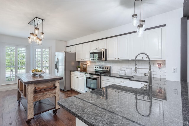 4045 Sun King Ln, Frisco, TX 75033 - kitchen featuring tasteful backsplash, a sink, dark stone counters, stainless steel appliances, and white cabinetry