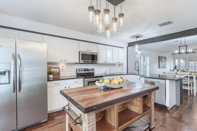 4045 Sun King Ln, Frisco, TX 75033 - kitchen featuring white cabinets, stainless steel appliances, a peninsula, backsplash, and visible vents