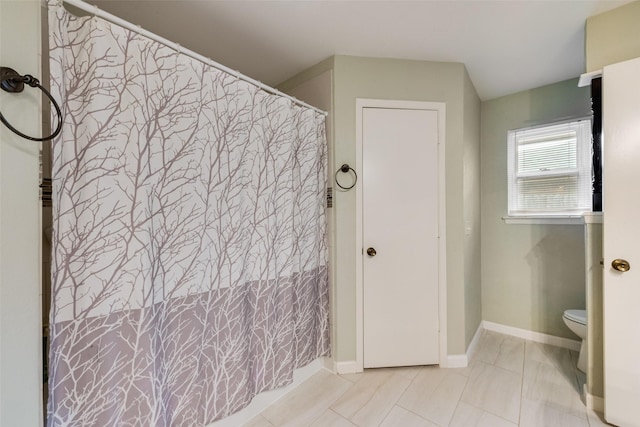 full bath with baseboards and toilet