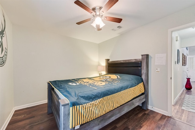 bedroom featuring baseboards, visible vents, and wood finished floors
