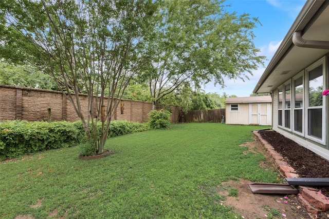 view of yard featuring a storage shed, an outdoor structure, and a fenced backyard