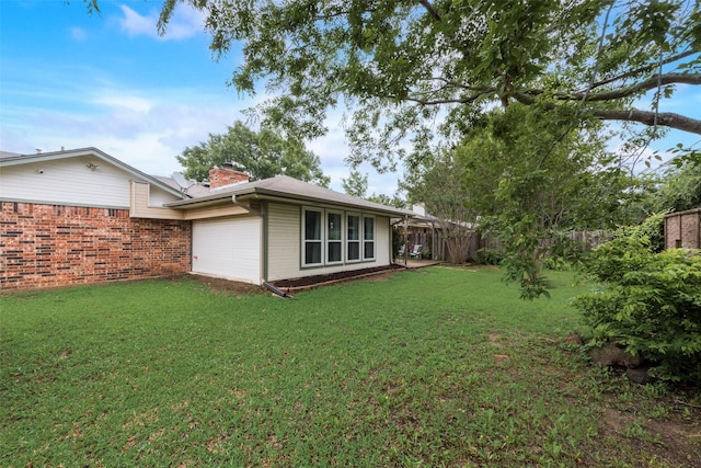 exterior space featuring an attached garage and fence