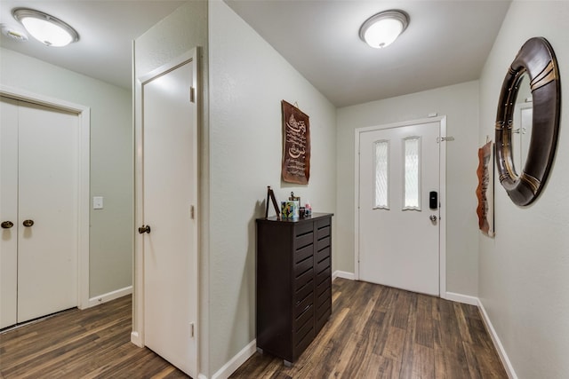 foyer featuring baseboards and wood finished floors