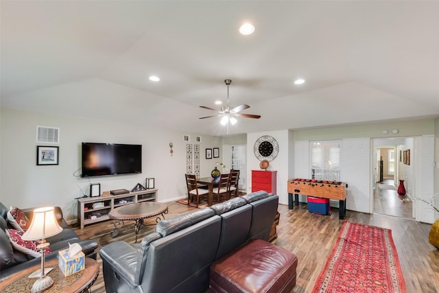 living area featuring ceiling fan, lofted ceiling, wood finished floors, and visible vents