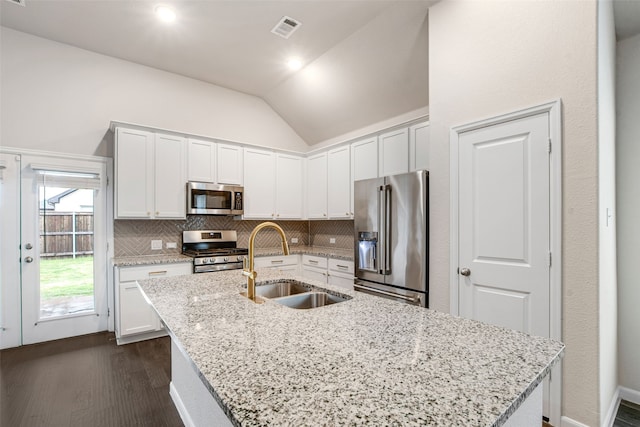 5608 Crestview Dr, Celina, TX 75009 - kitchen featuring lofted ceiling, white cabinetry, tasteful backsplash, a sink, and appliances with stainless steel finishes