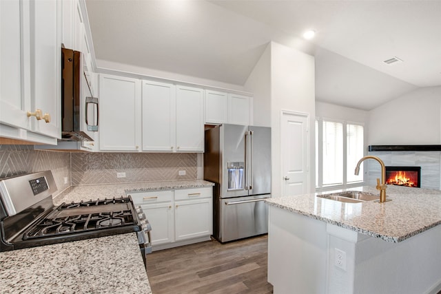 5608 Crestview Dr, Celina, TX 75009 - kitchen with a sink, stainless steel appliances, white cabinetry, lofted ceiling, and light wood-type flooring