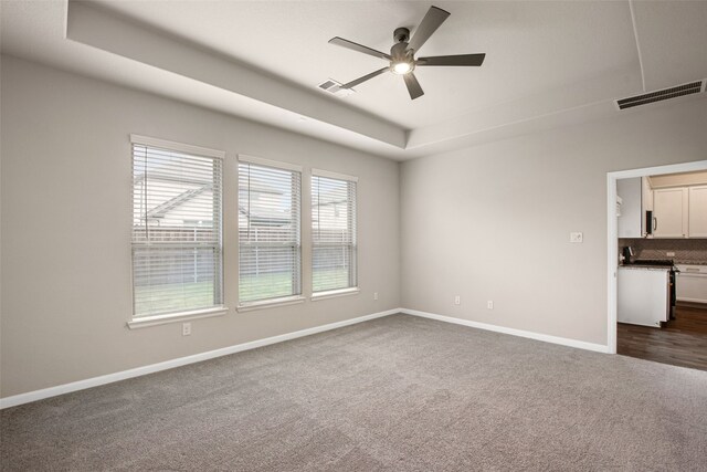 5608 Crestview Dr, Celina, TX 75009 - spare room with visible vents, baseboards, dark carpet, a tray ceiling, and a ceiling fan