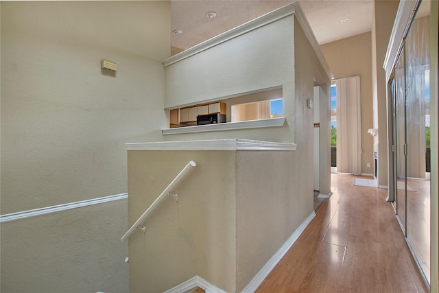 corridor featuring baseboards and wood finished floors