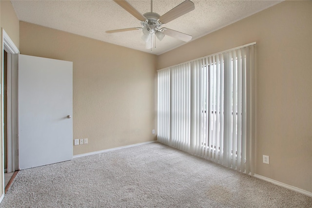 unfurnished room featuring carpet floors, a textured ceiling, ceiling fan, and baseboards