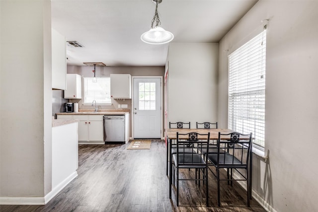 dining space with baseboards, wood finished floors, and visible vents