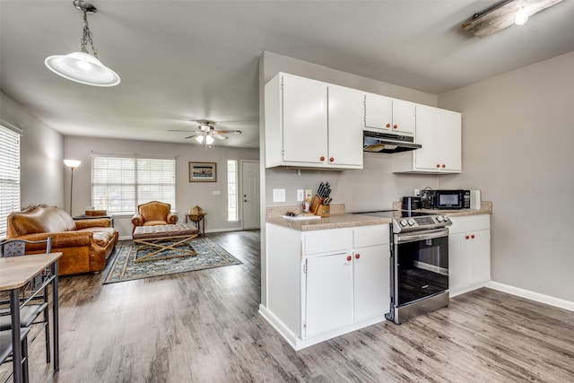 kitchen with electric range, black microwave, light wood-style floors, light countertops, and under cabinet range hood