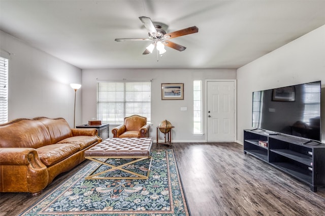 living area with baseboards, a ceiling fan, and wood finished floors
