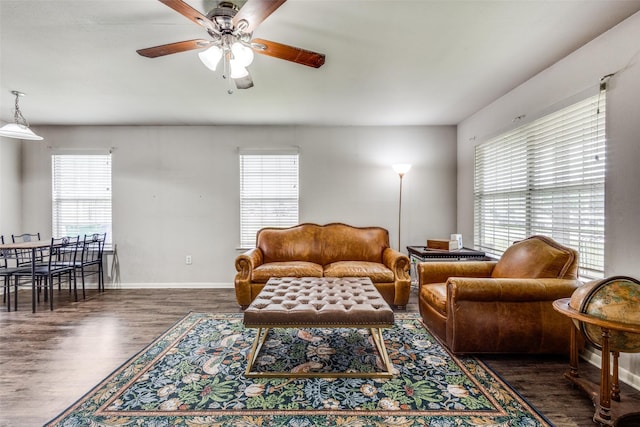 living room featuring baseboards, ceiling fan, and wood finished floors