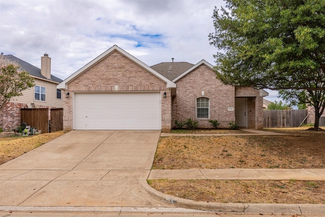 ranch-style home featuring fence, an attached garage, driveway, and brick siding