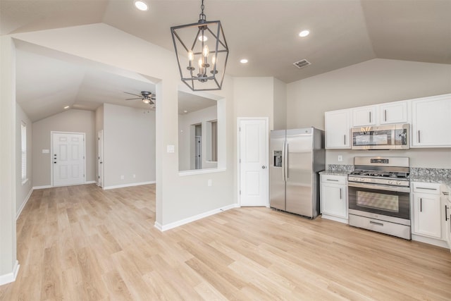 kitchen with pendant lighting, white cabinets, vaulted ceiling, and stainless steel appliances