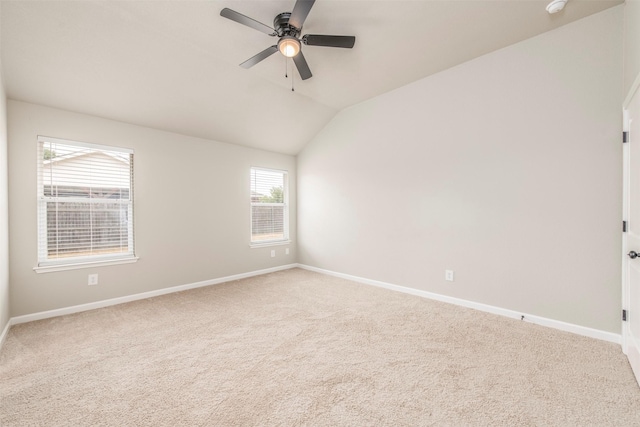 carpeted empty room with baseboards, vaulted ceiling, and ceiling fan