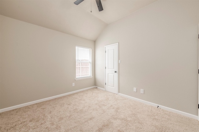 carpeted spare room with baseboards, ceiling fan, and vaulted ceiling