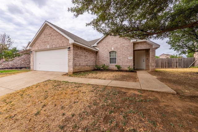ranch-style house with fence, an attached garage, concrete driveway, and brick siding