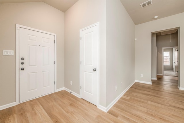 foyer with baseboards, visible vents, lofted ceiling, and light wood-type flooring